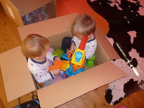 Kinder in Kiste samt Spielzeug